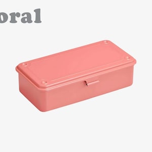 May include: A coral-colored rectangular storage box with a matching lid. The box has rounded corners and a small metal latch. The word "coral" is printed in gray in the upper left corner.