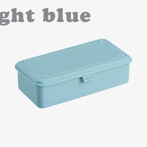 May include: A light blue rectangular box with a matching lid. The lid has a decorative border and is secured with a small latch. The words "light blue" are printed above the box.