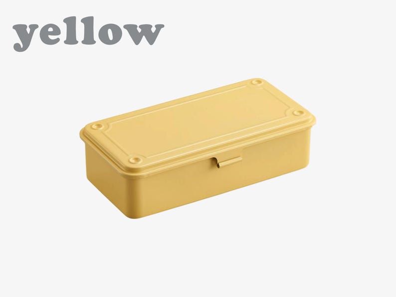 May include: A yellow rectangular box with a lid, featuring rounded corners and a small latch. The word "yellow" is printed in gray above the box. The box is a solid, pale yellow color.