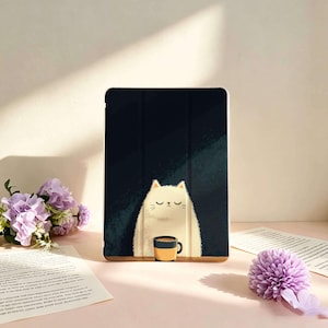 May include: A rectangular tablet case featuring a dark navy blue background with a central illustration of a fluffy, cream-coloured cat with closed eyes sitting behind a small, orange and black coffee mug on a wooden surface.