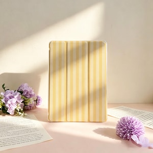 May include: A rectangular tablet case featuring a vertical striped pattern in alternating shades of pale yellow and cream. The protective cover has a tri-fold design with visible creases, providing a structured appearance for the electronic device.