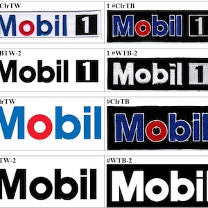 May include: A collection of embroidered patches featuring the "Mobil 1" logo. The patches display the logo in various color combinations, including white, black, red, and blue. The text "Mobil 1" is prominently displayed on each patch.