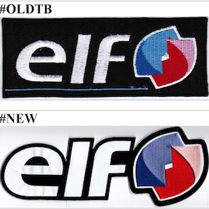 Può includere: Due toppe ricamate con la parola "elf" in bianco e un logo. La toppa superiore è su tessuto nero, quella inferiore su bianco. Il logo presenta elementi blu, rossi e rosa, creando un design distintivo.