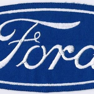 May include: Embroidered patch featuring the Ford logo. The logo is a white script font inside a blue oval with a white border. The patch is made of fabric and is likely designed to be sewn or ironed onto clothing or accessories.