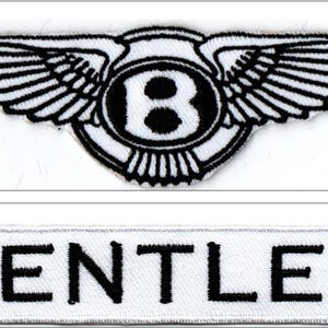 Puede incluir: Dos parches bordados. El parche superior es un emblema blanco con alas negras y una "B" negra en un círculo. El parche inferior es un rectángulo blanco con la palabra "BENTLEY" en letras negras.