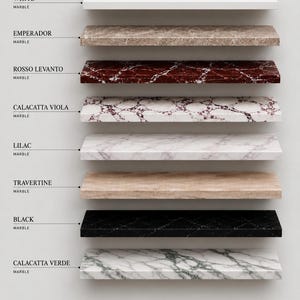 Könnte beinhalten: Eine Sammlung von acht rechteckigen Marmorplatten, die horizontal angeordnet sind. Die Beschriftungen identifizieren die Sorten als White, Emperador, Rosso Levanto, Calacatta Viola, Lilac, Travertine, Black und Calacatta Verde Marmor, wobei jede Platte ausgeprägte natürliche Maserungen und Farbmuster aufweist.