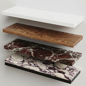 Pu&ograve; includere: Una pila di cinque mensole rettangolari sospese con finiture distinte: una mensola bianca solida, una con venature del legno, una in marmo rosso scuro con venature bianche, una in marmo bianco con venature viola e una mensola nera solida.