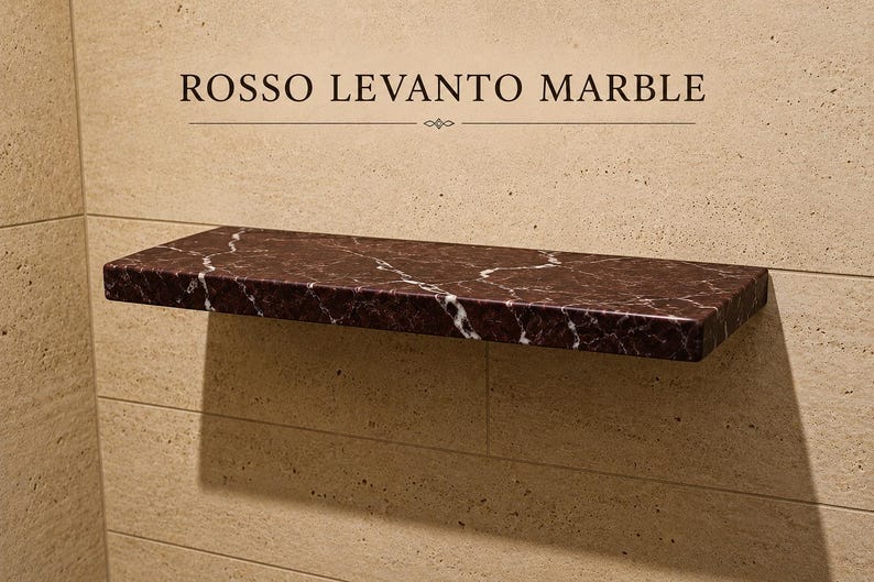 Pu&ograve; includere: Una mensola rettangolare sospesa in marmo rosso scuro Rosso Levanto con venature bianche prominenti. La mensola &egrave; montata orizzontalmente su una parete in pietra beige chiaro. Il testo ROSSO LEVANTO MARBLE &egrave; stampato sopra la mensola.