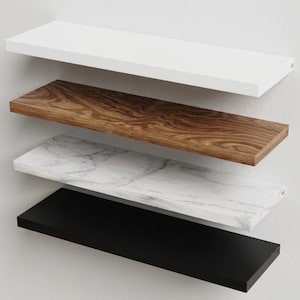 Pu&ograve; includere: Una pila di quattro mensole rettangolari sospese montate orizzontalmente. La mensola superiore &egrave; bianco tinta unita, la seconda presenta una venatura del legno marrone, la terza ha una texture in marmo bianco e grigio e la mensola inferiore &egrave; nero opaco.