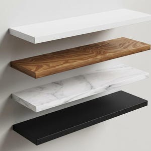Pu&ograve; includere: Quattro mensole rettangolari sospese montate orizzontalmente su una parete. La mensola superiore &egrave; bianco tinta unita, la seconda presenta una venatura del legno marrone, la terza ha una finitura in marmo bianco con venature grigie e quella inferiore &egrave; nero tinta unita.