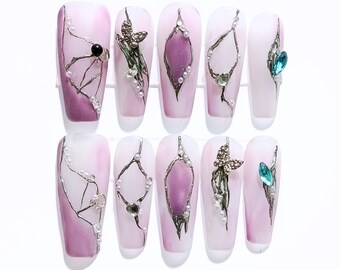 Unghie di lusso rosa sfumate con ciondoli 3D, decorazione a farfalla con venature dorate e strass.