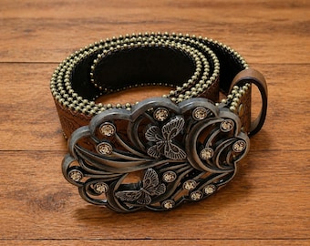 Cintura western in pelle marrone con fibbia decorata a filigrana e cinturino con motivo floreale in rilievo, per uomo e donna.