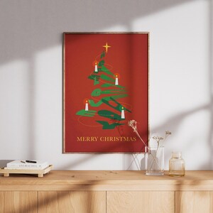 Puede incluir: Una impresión artística navideña enmarcada con un árbol de Navidad verde estilizado con velas blancas y una estrella dorada sobre un fondo rojo. Las palabras "MERRY CHRISTMAS" están impresas en oro en la parte inferior.