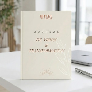 Peut inclure: Un journal crème avec le texte "RITUEL D'ANCRAGE" et "JOURNAL DE VISION & TRANSFORMATION" en couleur cuivre. Un motif floral blanc est sur le coin inférieur droit. Un stylo et un ordinateur portable sont en arrière-plan.