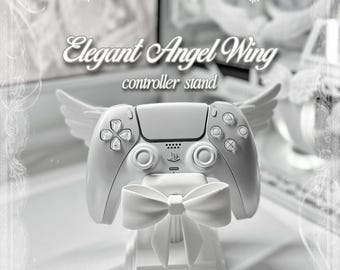 Puede incluir: Un soporte para mando de color blanco con alas de ángel esculpidas en los laterales y un lazo prominente en la parte frontal. El soporte sostiene un mando de juego blanco. El texto en la imagen dice Elegant Angel Wing controller stand y by kissesfromangels.
