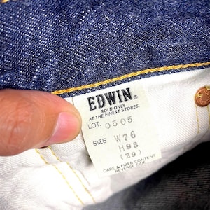 K&ouml;nnte beinhalten: Nahaufnahme der Innenseite einer blauen Jeans. Ein wei&szlig;es Etikett zeigt die Marke "EDWIN" und Gr&ouml;&szlig;enangaben: W76, H93 (29). Das Etikett enth&auml;lt auch den Text "SOLD ONLY AT THE FINEST STORES."