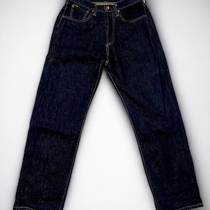 K&ouml;nnte beinhalten: Dunkelblaue Jeans mit klassischem F&uuml;nf-Taschen-Design. Die Jeans hat einen Knopf- und Rei&szlig;verschluss und sichtbare N&auml;hte in kontrastierendem gelbem Faden. Die Jeans liegen flach auf einem wei&szlig;en Hintergrund.