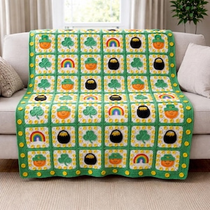 May include: A crocheted blanket featuring a repeating pattern of St. Patrick's Day symbols. The squares include orange leprechauns, green shamrocks, rainbows, and black pots of gold. The blanket is bordered in green with yellow accents.