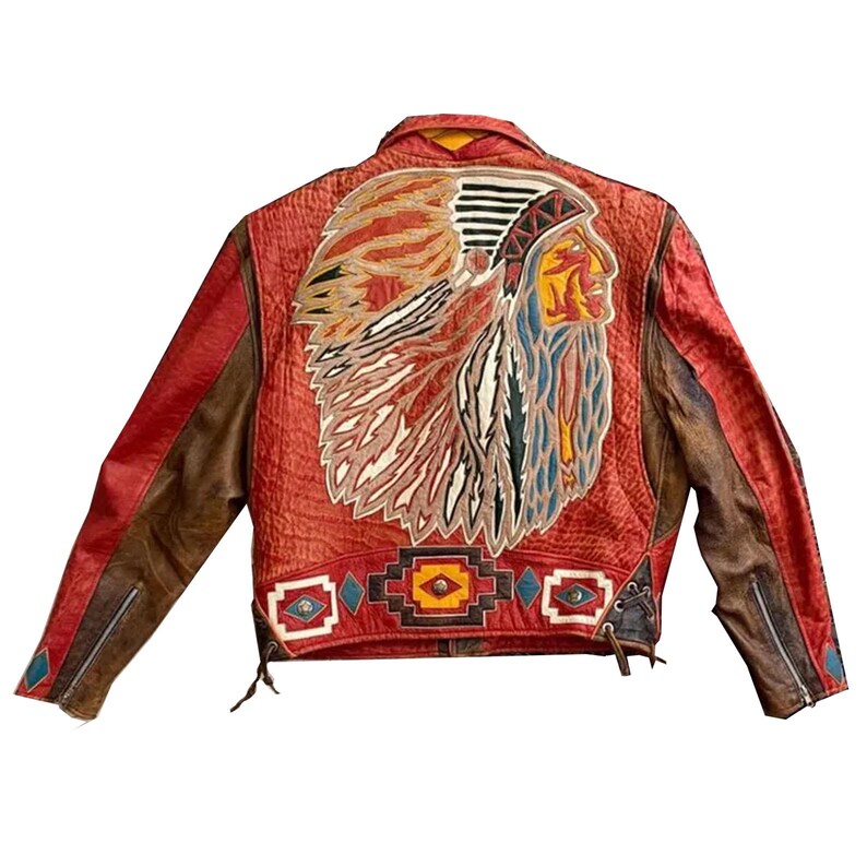 May include: A red and brown leather jacket featuring a large, detailed back appliqu&eacute; of a person wearing a feathered headdress. The lower back panel displays a geometric pattern in red, black, yellow, and blue, with metal stud accents.