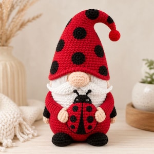 Peut inclure: Une poupée gnome au crochet faite à la main avec un chapeau rouge à pois noirs. Le gnome a une barbe blanche, un nez beige et tient une coccinelle. Le corps du gnome est rouge avec des accents noirs. Un objet décoratif fantaisiste.