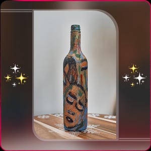 May include: A hand-painted wine bottle with an abstract face design in orange, blue, and green. The bottle has a textured surface and a green neck. The artwork is expressive, adding a unique touch to home decor. The bottle is approximately 30 cm tall.