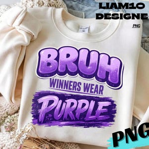 Può includere: Felpa color crema con le parole "BRUH WINNERS WEAR PURPLE" in viola, con un font in stile bolla. Il testo è sovrapposto a un design a pennellate viola. La felpa ha un girocollo e maniche lunghe.