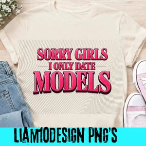 May include: Cream-colored t-shirt with the text "SORRY GIRLS I ONLY DATE MODELS" in pink and black. The shirt is paired with blue jeans and pink sneakers. The bottom of the shirt has the text "LIAM10DESIGN PNG'S" in black.