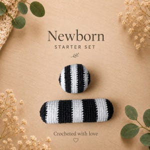 Könnte beinhalten: Ein Neugeborenen-Starterset bestehend aus einem kugelförmigen Häkelball und einer zylindrischen Häkelrassel, beide mit abwechselnden schwarzen und weißen Streifen. Der Text Newborn STARTER SET und Crocheted with love ist abgebildet.