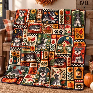 May include: A rectangular throw blanket featuring a patchwork design of Schnauzer dogs in various autumn-themed scenes, including sunflowers, pumpkins, mushrooms, and cozy cottages, rendered in a warm color palette of orange, brown, and green.
