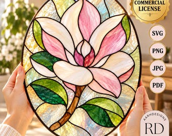 May include: An oval stained glass panel featuring a central magnolia flower with white and pink petals, green leaves, and a brown stem. The background consists of textured, iridescent glass pieces. The image includes text labels for Commercial License, SVG, PNG, JPG, PDF, and AARHDESIGNS RD Designs.
