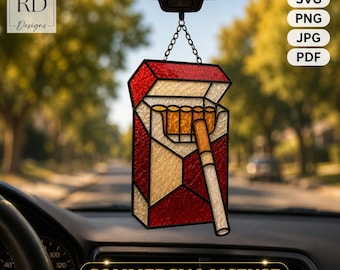 May include: A stained glass car ornament shaped like an open cigarette pack with red and cream textured glass panels, featuring a single cigarette protruding from the top, suspended by a black metal chain from a rearview mirror.