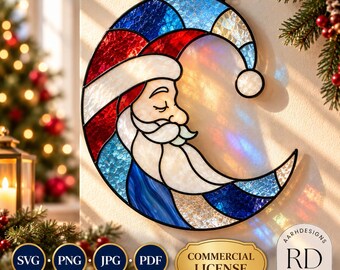 May include: A crescent-shaped stained glass suncatcher featuring a profile of Santa Claus with a white beard and hat. The design uses textured blue, red, and white glass pieces held together by black lead lines, hanging from a black chain.