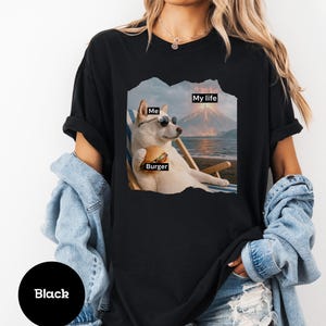 May include: Black t-shirt featuring a graphic of a dog wearing sunglasses, holding a burger, and relaxing on a beach chair. Text on the graphic reads "Me", "Burger", and "My life".