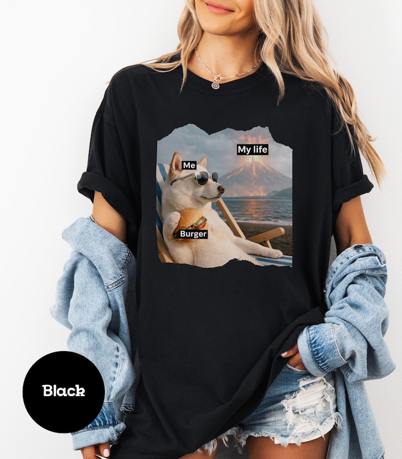 May include: Black t-shirt featuring a graphic of a dog wearing sunglasses, holding a burger, and relaxing on a beach chair. Text on the graphic reads "Me", "Burger", and "My life".