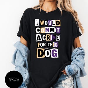 May include: Black t-shirt with the text "I WOULD COMMIT A CRIME FOR THIS DOG" in white, yellow, and purple block letters. The shirt is a crew neck style.