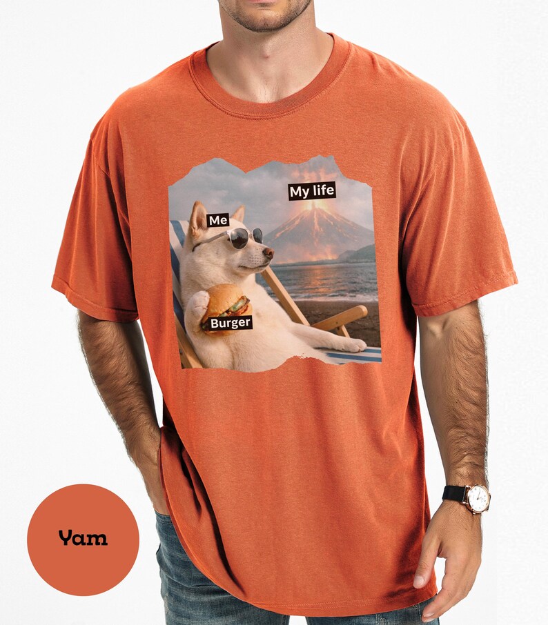 May include: Orange t-shirt with a graphic of a dog wearing sunglasses, holding a burger, and relaxing on a beach chair. The image includes the text "Me", "Burger", and "My life".