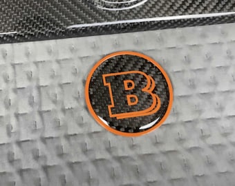 Logo Brabus en fibre de carbone avec garniture orange pour capot Mercedes Classe G