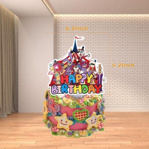Op de afbeelding: Een versierde verjaardagstaart met een kleurrijke circus-thema topper met de tekst "Happy Birthday". De taart is roze met gele en groene frosting en stervormige decoraties. De topper is 15,7 cm hoog.