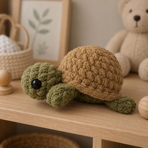 May include: A crochet turtle toy featuring a textured, light brown rounded shell and a dark olive green head and limbs. The turtle has large, smooth, black plastic safety eyes and is crafted from soft, chunky yarn with visible stitches.