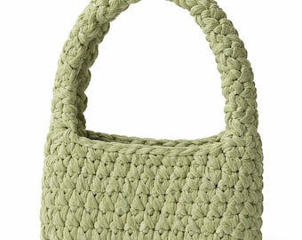 May include: A light green crochet handbag with a braided handle. The bag has a rectangular shape and a textured surface. The handle is thick and sturdy, and the bag appears to be made of a soft, plush material.
