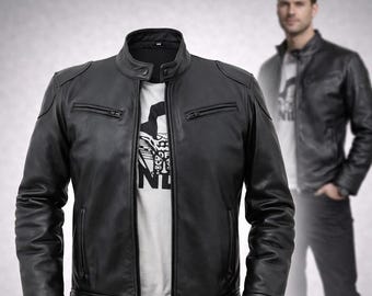 May include: Black leather jacket with a stand-up collar, two zippered chest pockets, and a front zipper closure. The jacket is worn over a white t-shirt with a graphic design. A person is wearing the jacket in the background.