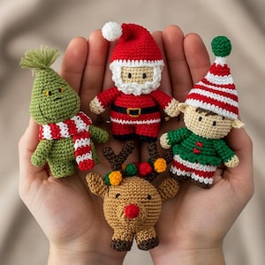 Puede incluir: Colección de cinco adornos navideños de ganchillo. Los adornos incluyen a Papá Noel, un elfo, un reno y un personaje verde con una bufanda roja y blanca. Los adornos están hechos a mano y presentan costuras detalladas.