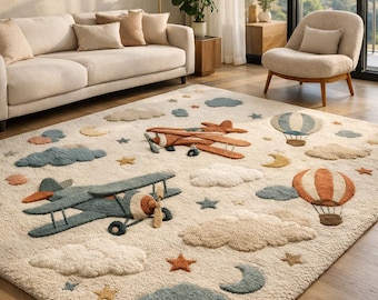 Alfombra infantil de aviación vintage: alfombra de lana tejida a mano con diseño de avión y globo aerostático para sala de juegos en suaves tonos pastel neutros.