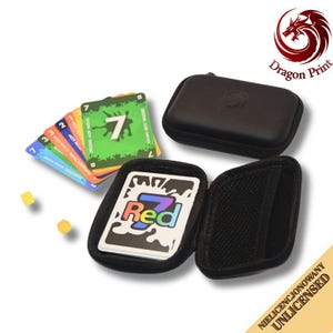 Op de afbeelding: Een zwarte etui met ritssluiting met een kaartspel met het label "Red 7" en een stapel kleurrijke kaarten. De kaarten hebben nummers en groene, blauwe, oranje en rode accenten. Twee gele dobbelstenen zijn ook zichtbaar.
