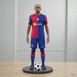 Op de afbeelding: Een beeldje van een voetballer in een blauw en rood shirt met het Spotify-logo. De speler draagt een blauwe short, sokken en schoenen en staat op een zwarte basis met een voetbal.