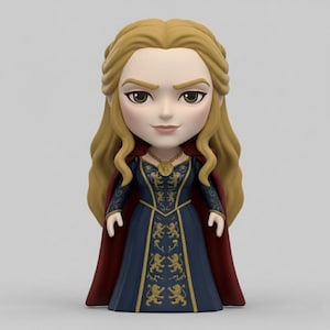 Pode incluir: Estatueta de uma mulher com longos cabelos loiros, vestindo um vestido azul escuro com emblemas de leão dourados e uma capa vermelha. A estatueta tem um colar de ouro e está em pé.