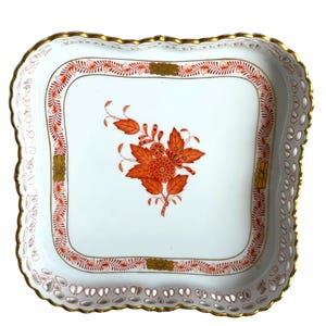 May include: A square porcelain serving dish with a white base, featuring a central orange floral motif. The border is decorated with an orange leaf pattern, gold accents, and a scalloped, pierced lattice edge finished with a gold-painted rim.