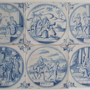 Puede incluir: Conjunto de seis azulejos de cerámica antiguos, cada uno con una ilustración azul y blanca dentro de un marco circular. Las escenas representan eventos bíblicos, con inscripciones de texto. Los azulejos tienen un diseño de borde floral.