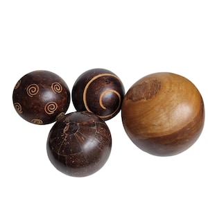 May include: Four wooden spheres in shades of brown. Two spheres feature spiral designs, one has a textured surface, and the fourth is a lighter wood tone. These decorative spheres are ideal for home decor, adding a natural touch.