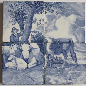 Könnte beinhalten: Ein Satz von vier blau-weißen Keramikfliesen, die eine ländliche Szene darstellen. Das Kunstwerk zeigt einen Bauern, Kühe und Schafe unter einem Baum. Die Fliesen sind so angeordnet, dass ein größeres Bild einer ländlichen Landschaft entsteht.